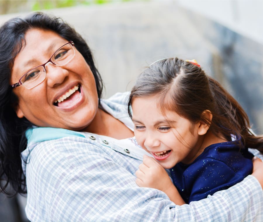Woman and young child smiling and laughing together.